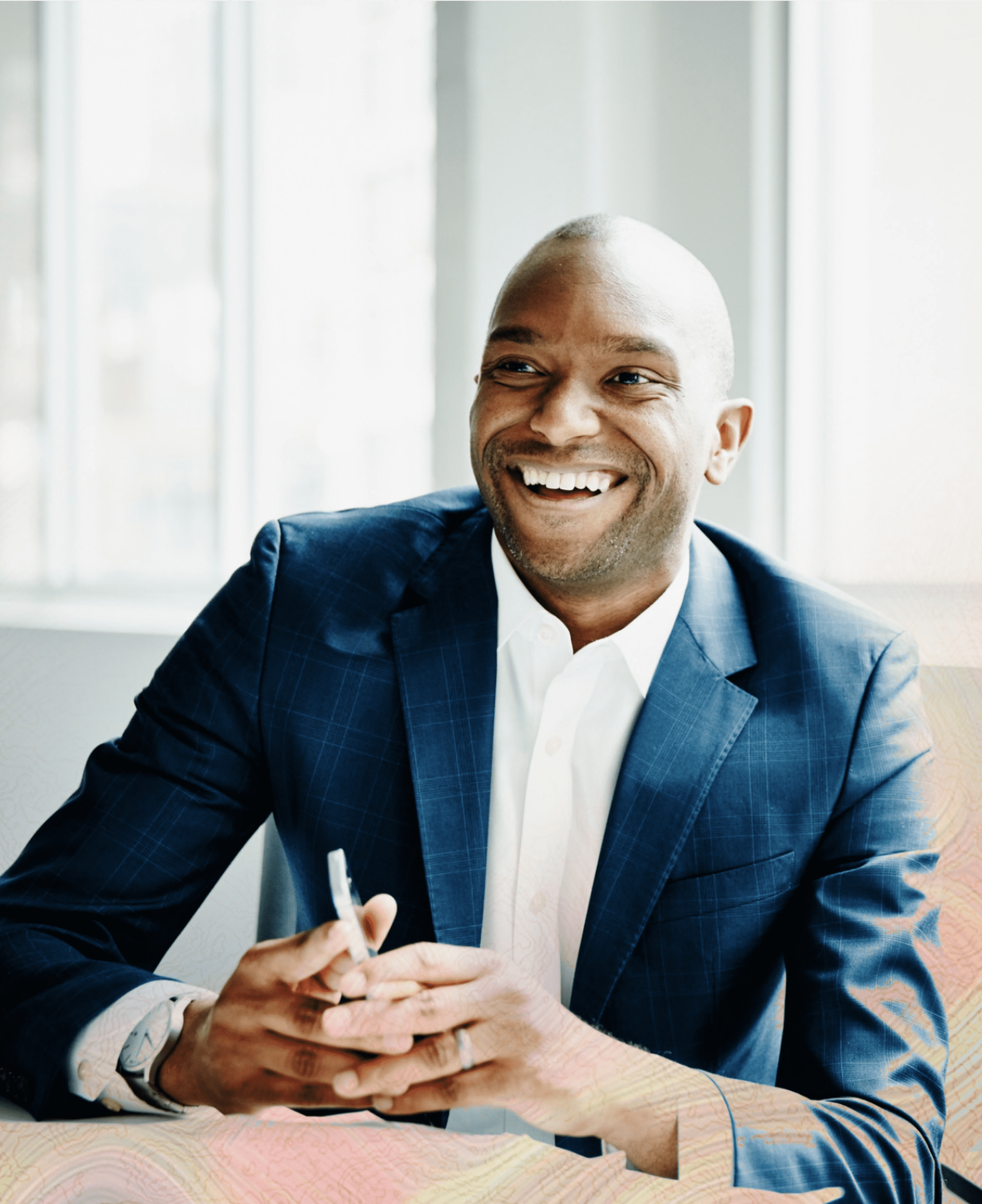 A man in a suit smiling.